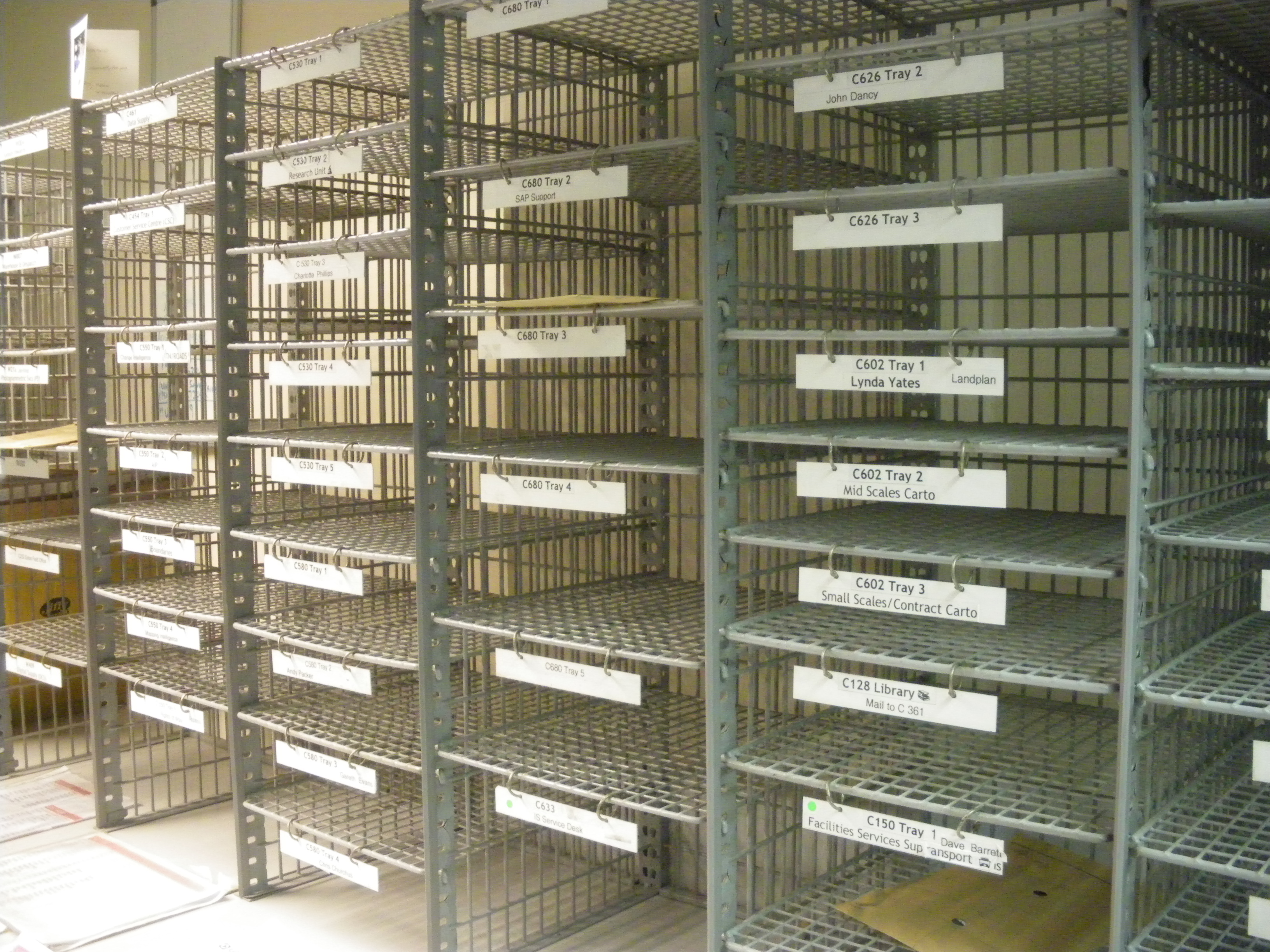 Red round mail racks in the Post Room (W005)